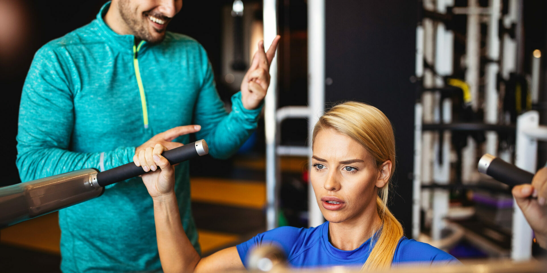 Woman with her personal fitness trainer in the gym exercising